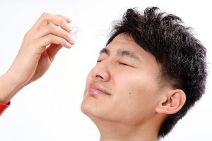 目薬をさす男性