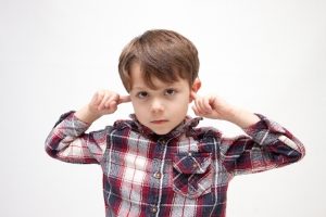 耳を塞ぐ少年