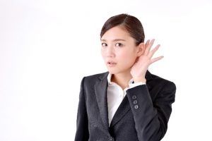 耳に手をやる女性