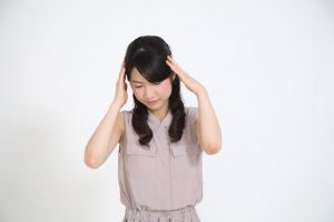 頭に手をやる女性