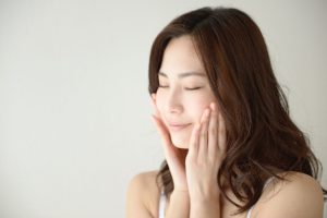 顔に手をやる女性