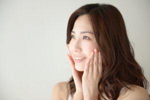 顔に手をやる女性