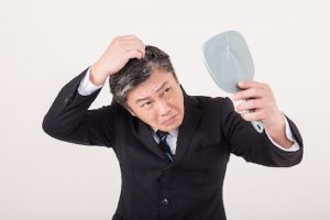 髪を触る男性