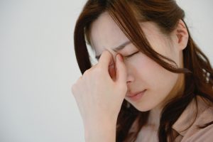 目頭を抑える女性