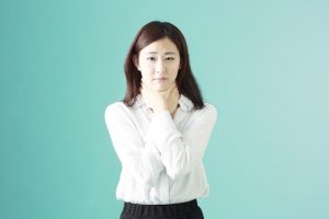 首に手をやる女性