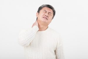 首に手を置く男性